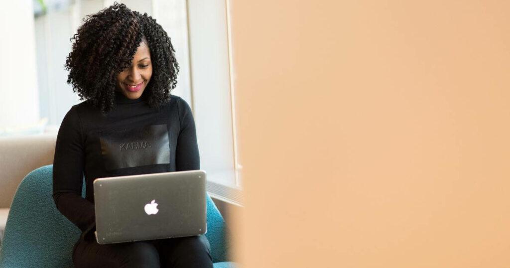 smiling woman looking at laptop