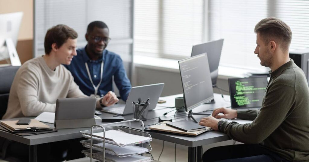 cybersecurity consulting partner with team on laptops