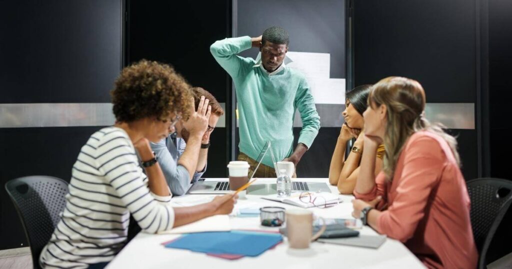 frustrated team sitting around table