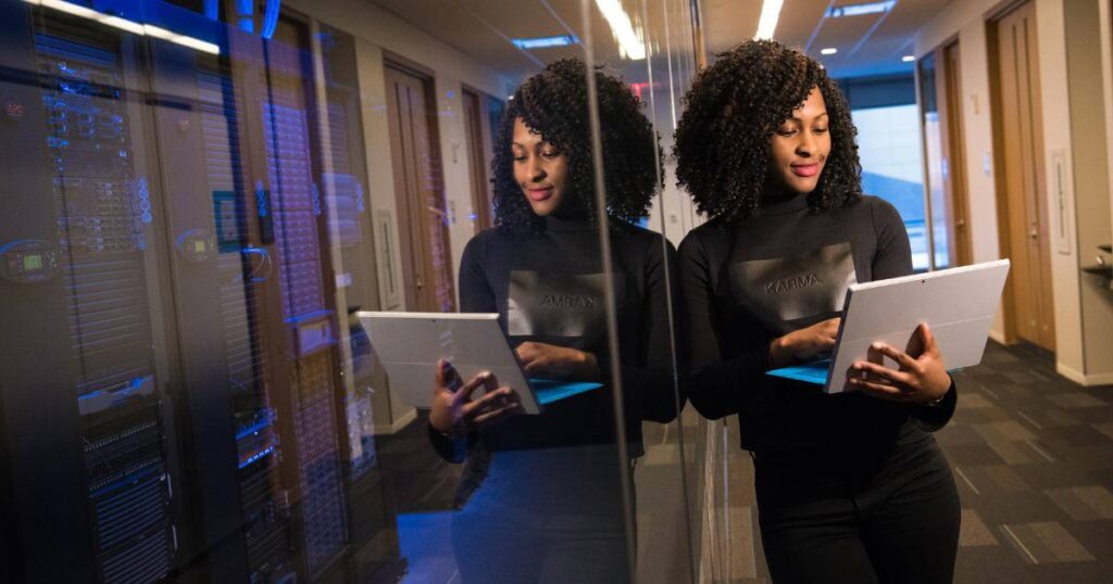 smiling female tech consultant holding laptop