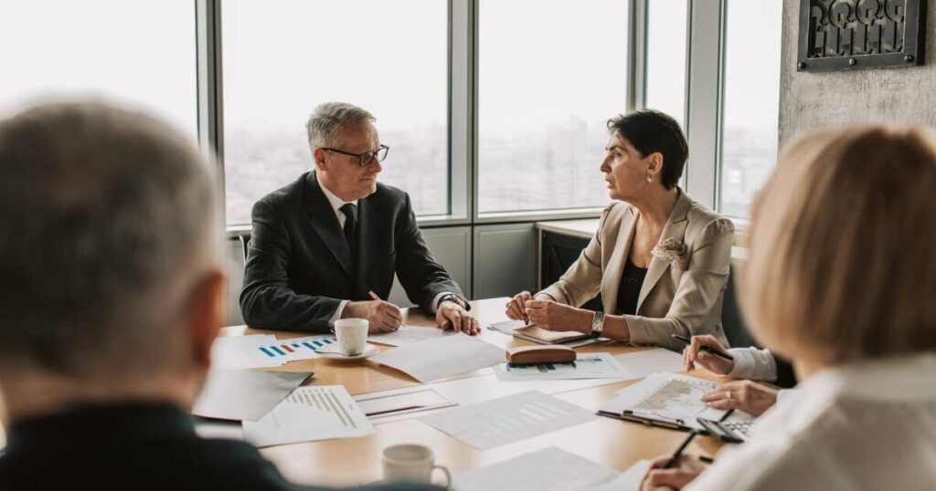 Business people around a conference table discussing hiring someone for an AI initiative