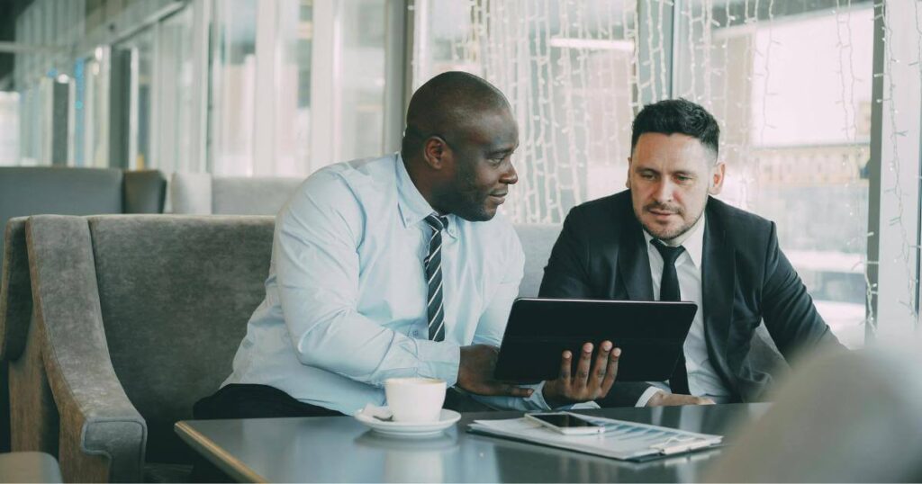 Two business professionals reviewing candidate information on a tablet, representing the relationship-driven approach of a specialized IT staffing partner