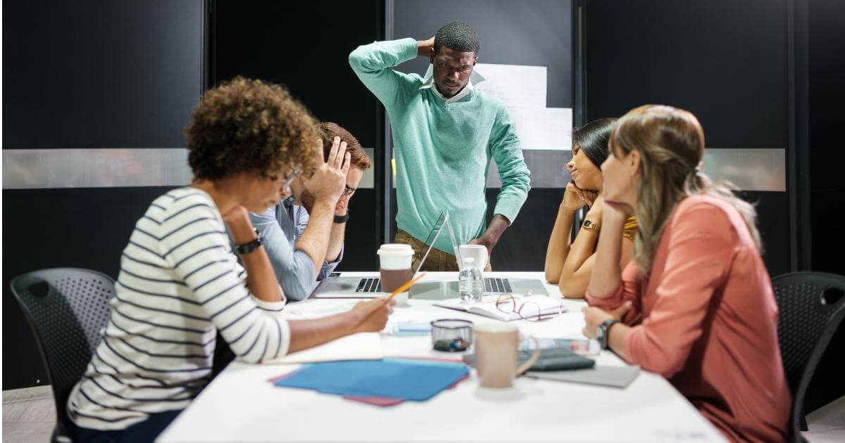 niche roles cost you IT team in a tense meeting reviewing a stalled project, illustrating the cost of a delayed niche IT search