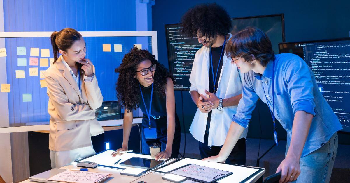 How to Build an AI-Native Engineering Team AI-native engineering team reviewing a project plan together, code visible on screens behind them